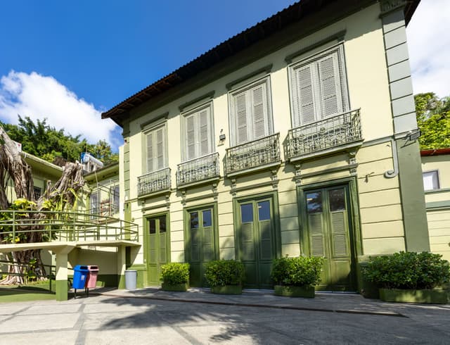 Um foto da unidade, com janelas brancas e portas verdes